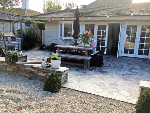 French doors open up to a backyard redesigned with hardscape rather than grass.